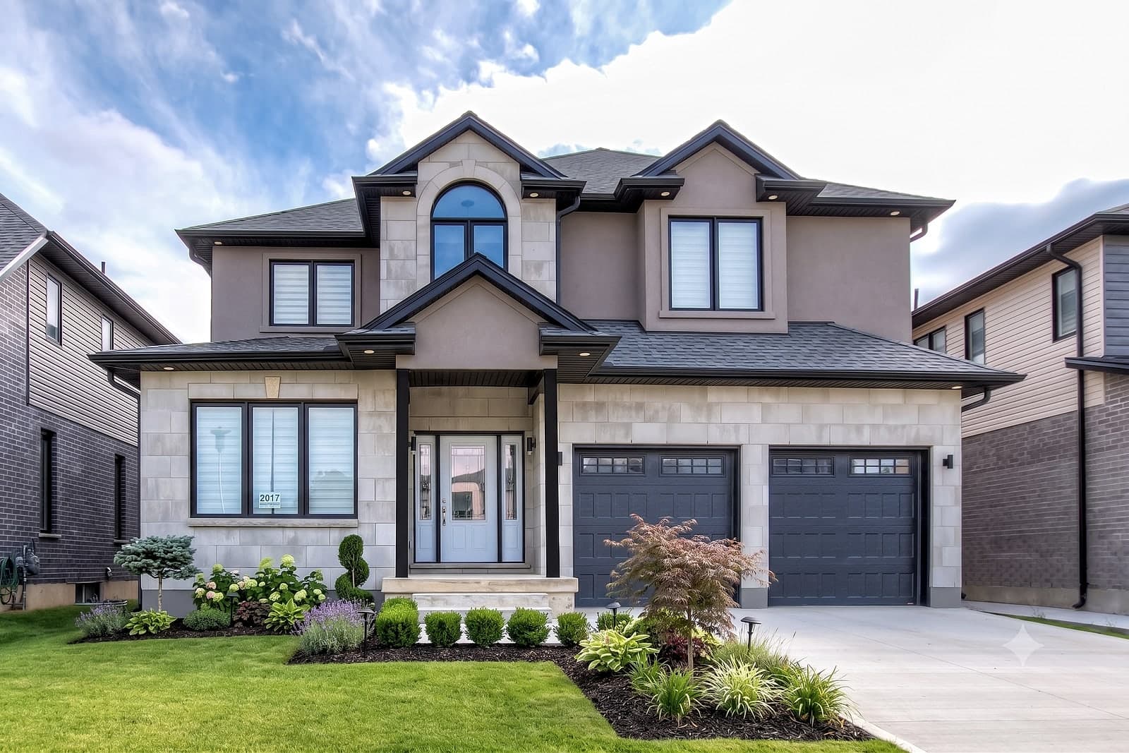 A completed Black Cedar home at Foxwood Crossings — stone-and-stucco two-storey with mature landscaping in London, Ontario