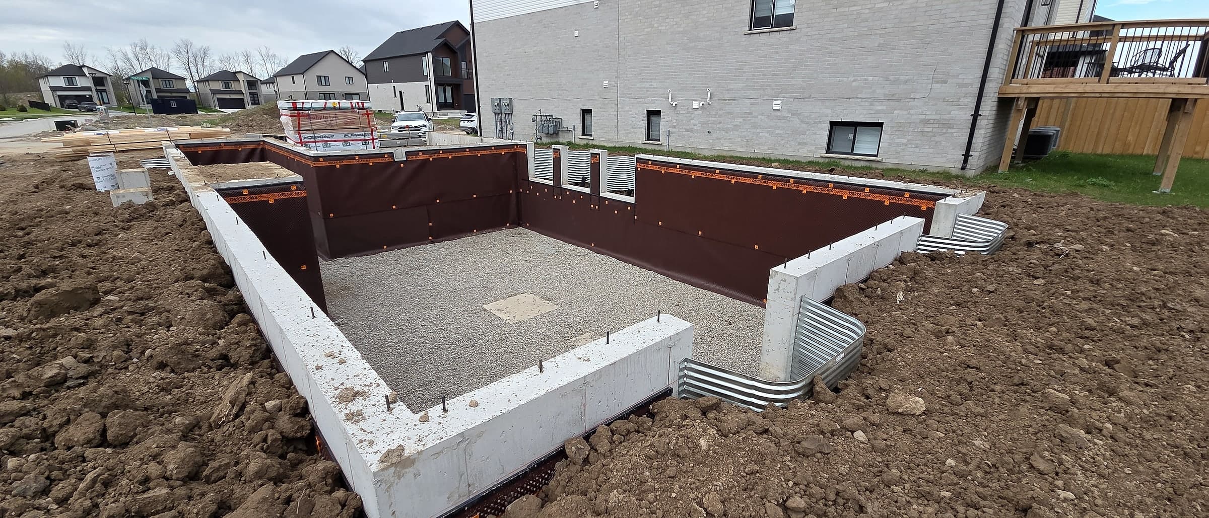 Foundation of a Black Cedar home wrapped in dimpled Delta waterproofing membrane before backfill