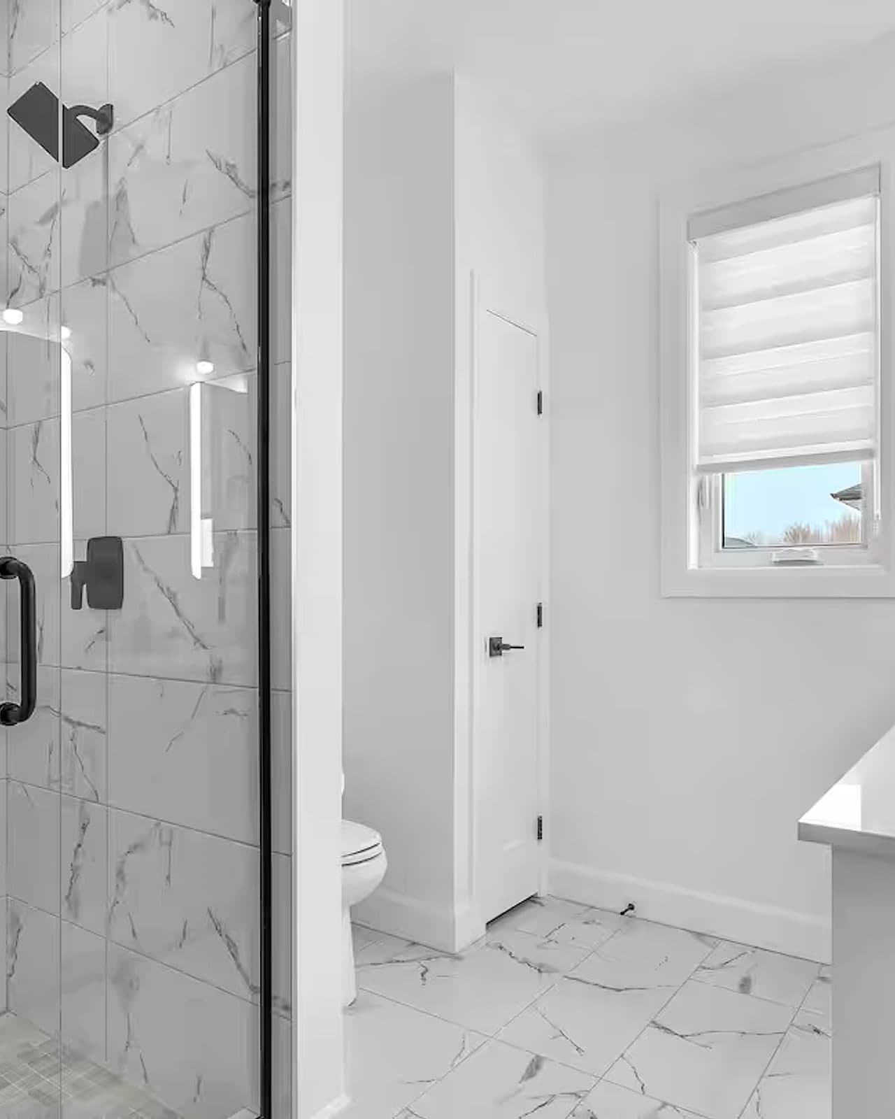 Ensuite with a glass shower and marble-look tile