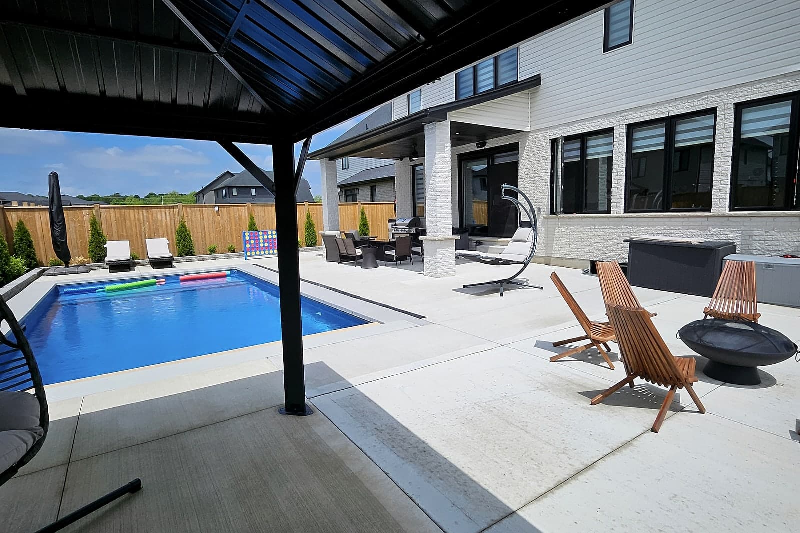 Backyard with an in-ground pool, a covered patio, and a fire lounge