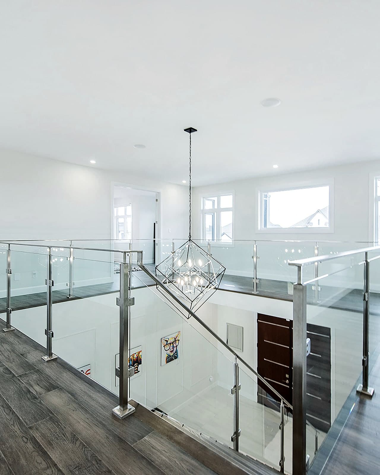 Upper landing with a glass railing overlooking the main floor