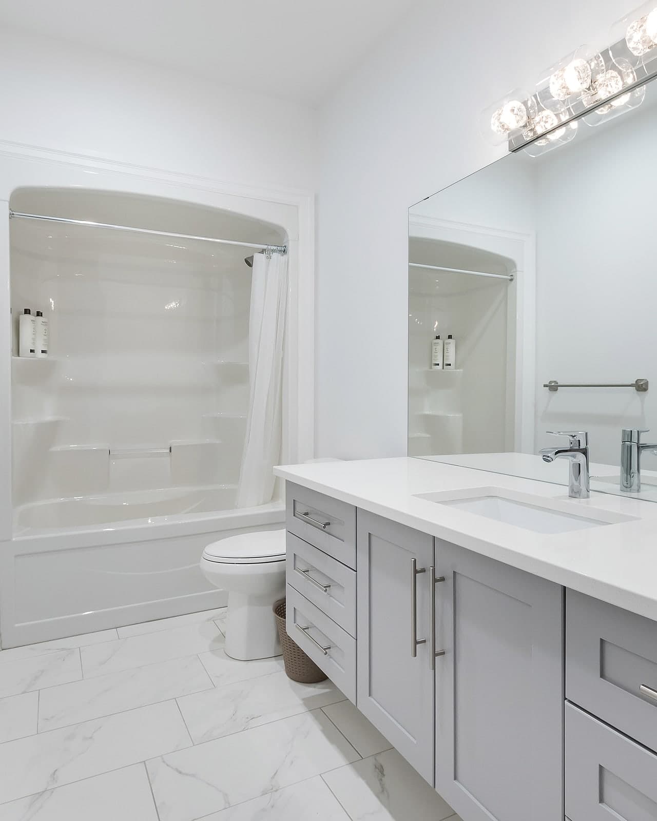 Full bathroom with a tub-shower and a quartz-topped vanity