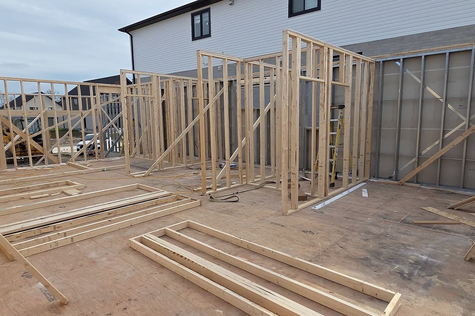 Main-floor wall framing rising on a Black Cedar custom home