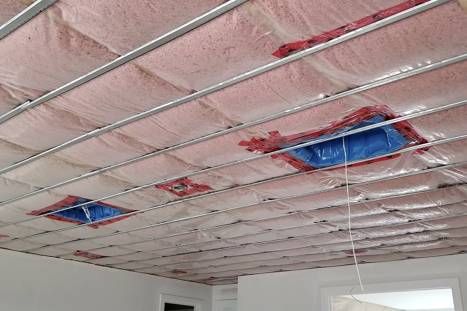 Pre-drywall stage in a Black Cedar home — vapour-sealed ceiling insulation and strapping in place