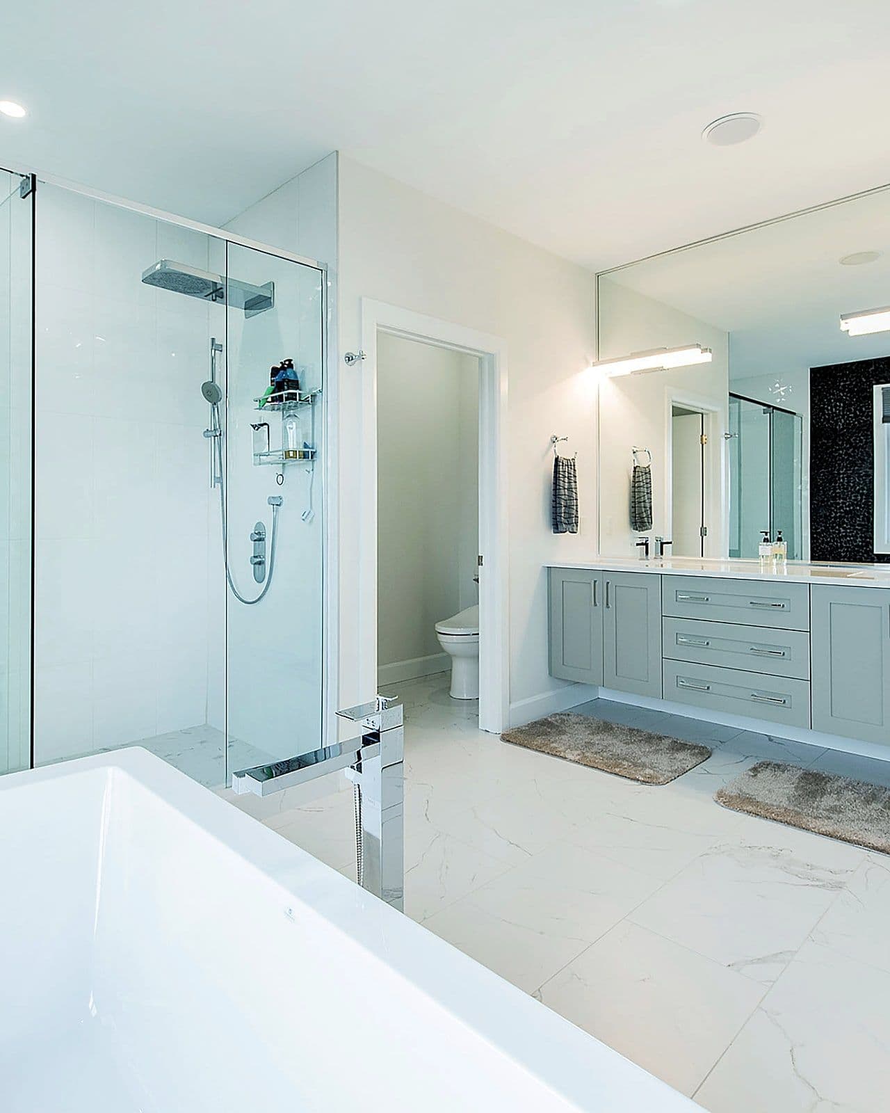Ensuite with a freestanding tub and glass shower in the Silverleaf show home