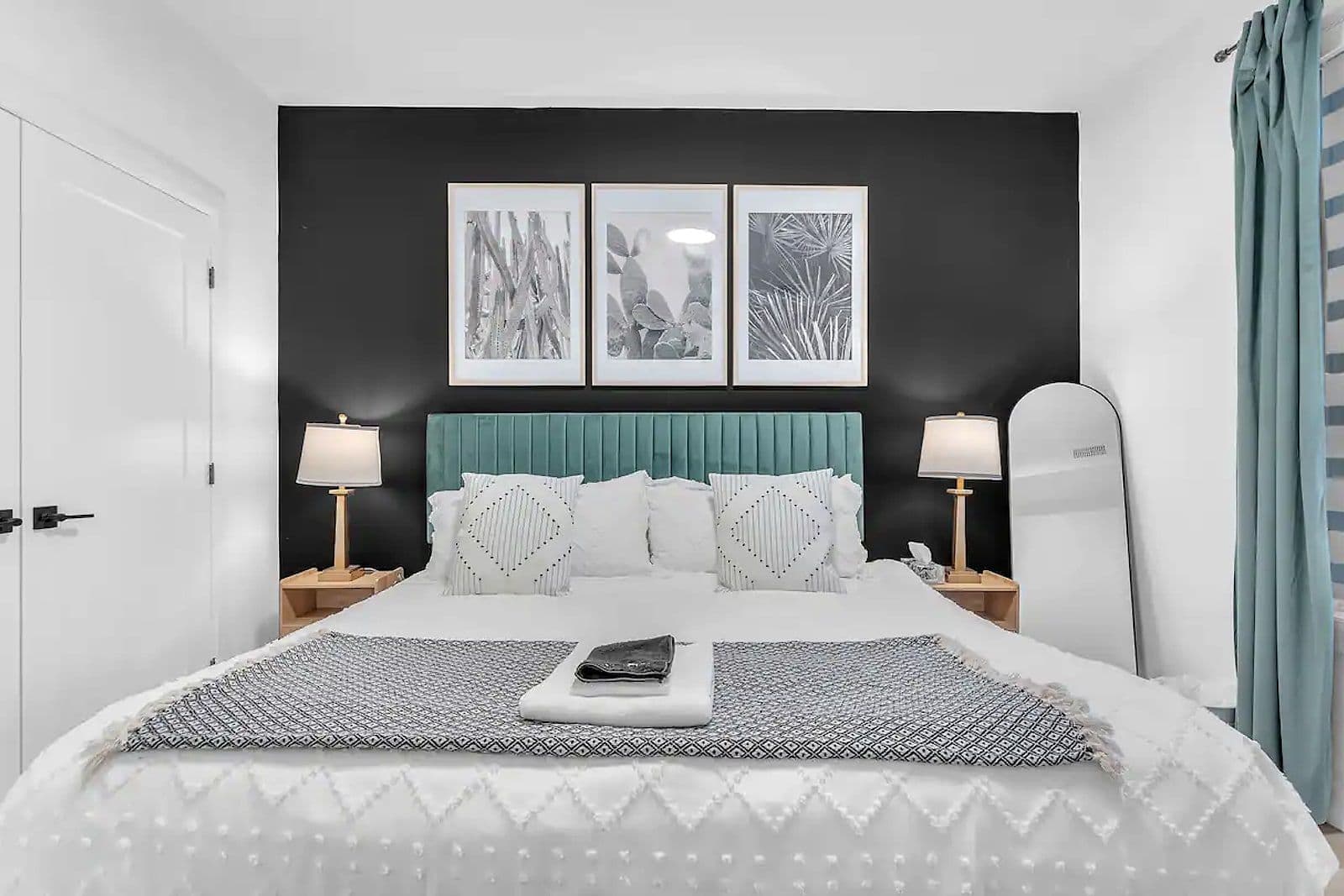 Bedroom with an upholstered headboard and a dark feature wall