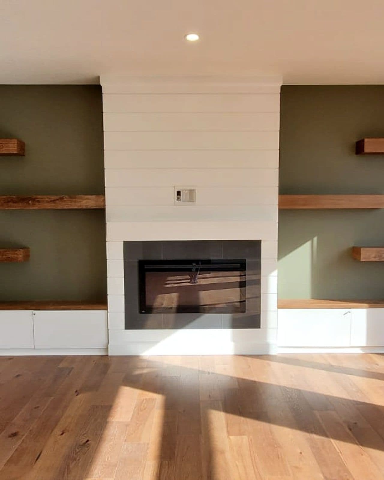 Living-room fireplace with reclaimed-wood shelving in a Canvas home by Black Cedar
