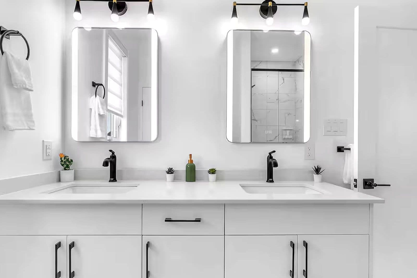 Double-vanity bathroom with backlit mirrors