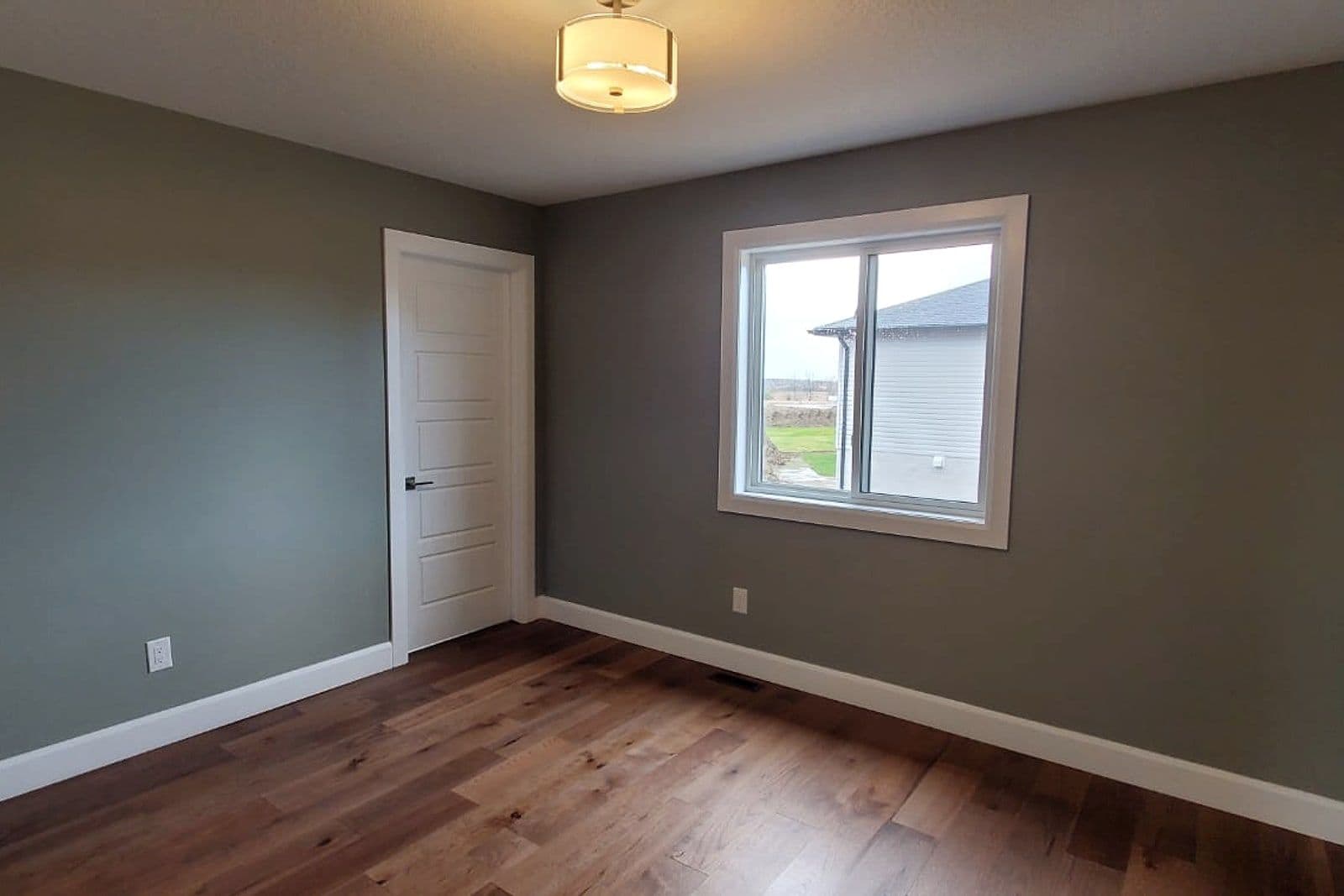 Bedroom with hardwood floors and a bright window