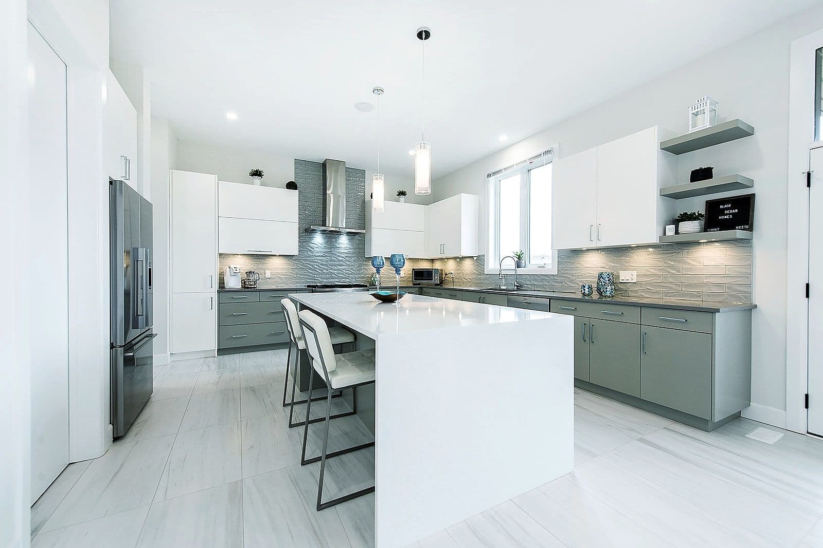 Kitchen island beneath linear pendant lighting