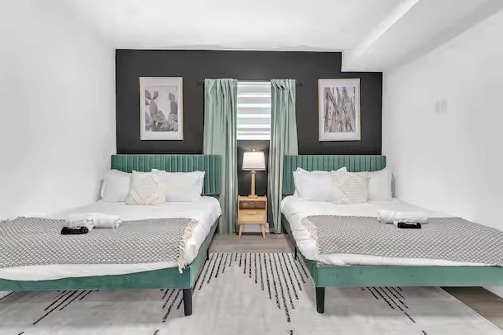 Bedroom with two beds and a green-panelled feature wall