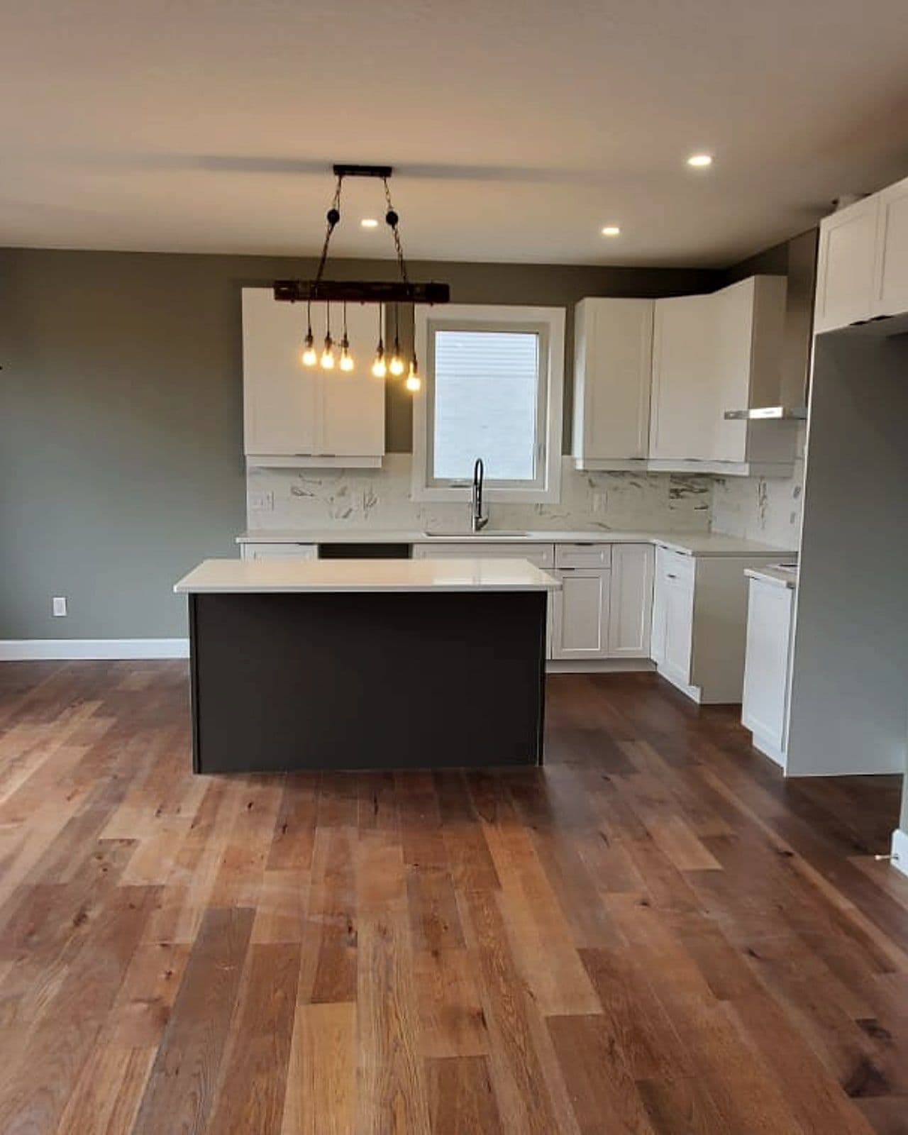 Kitchen with hardwood floors and an island in a Canvas home