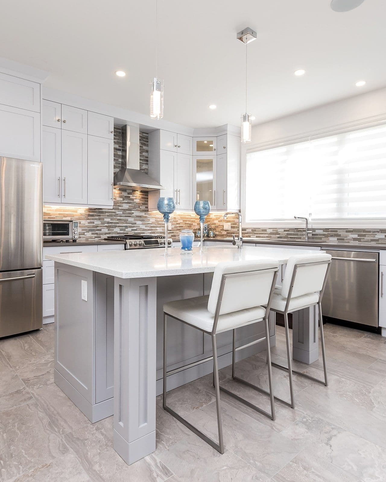 White kitchen with a quartz island in a Foxwood Crossings home